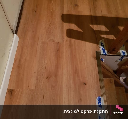 רצפת פרקט עץ עם גימור בהיר ופסי חיבור
